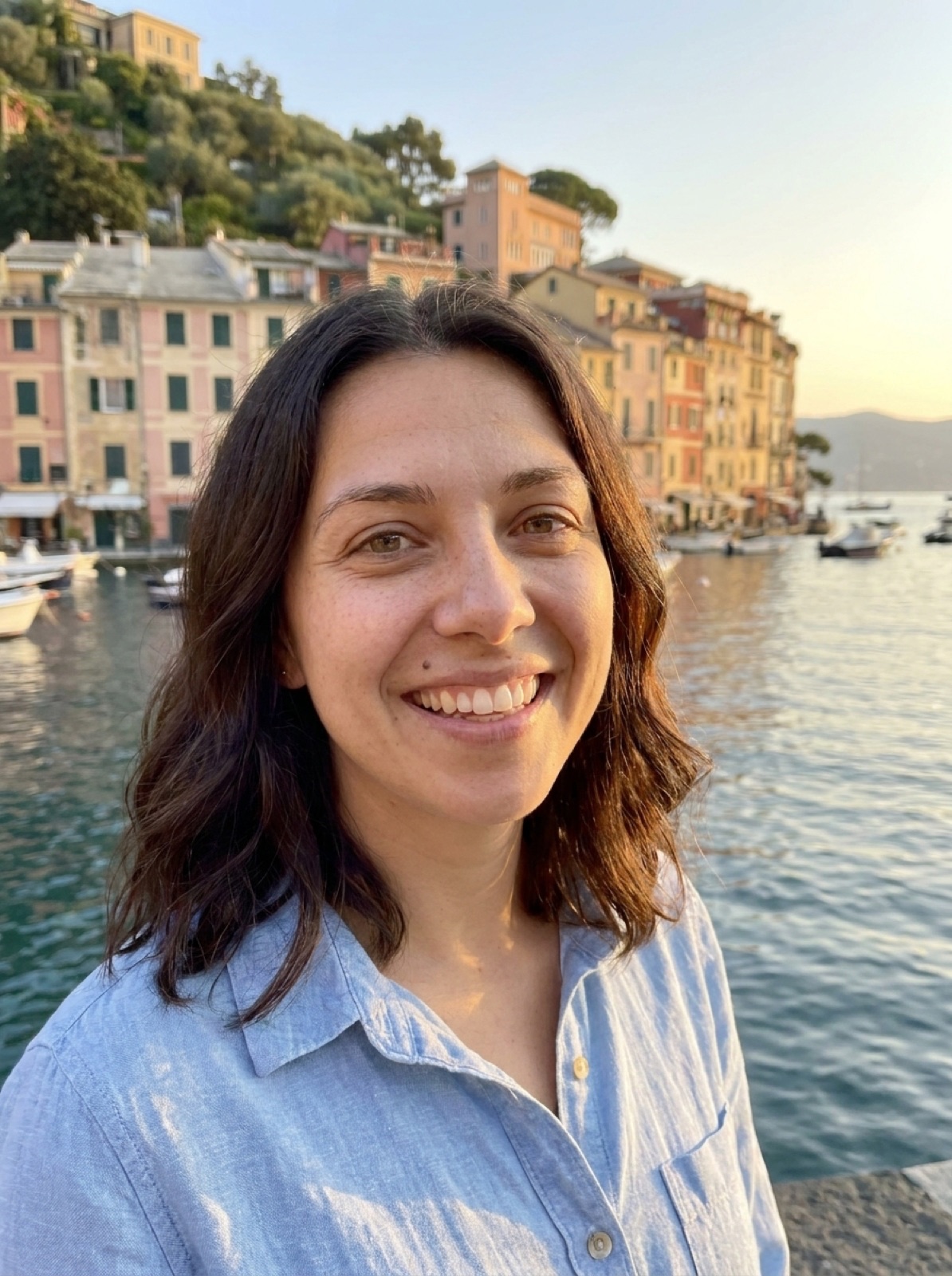 Mia smiling on the quay of Portofino harbour at golden hour